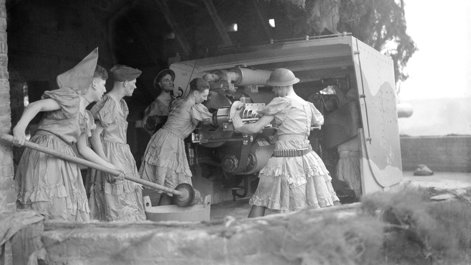 A group of British soldiers in drag operating heavy artillery during WWII.