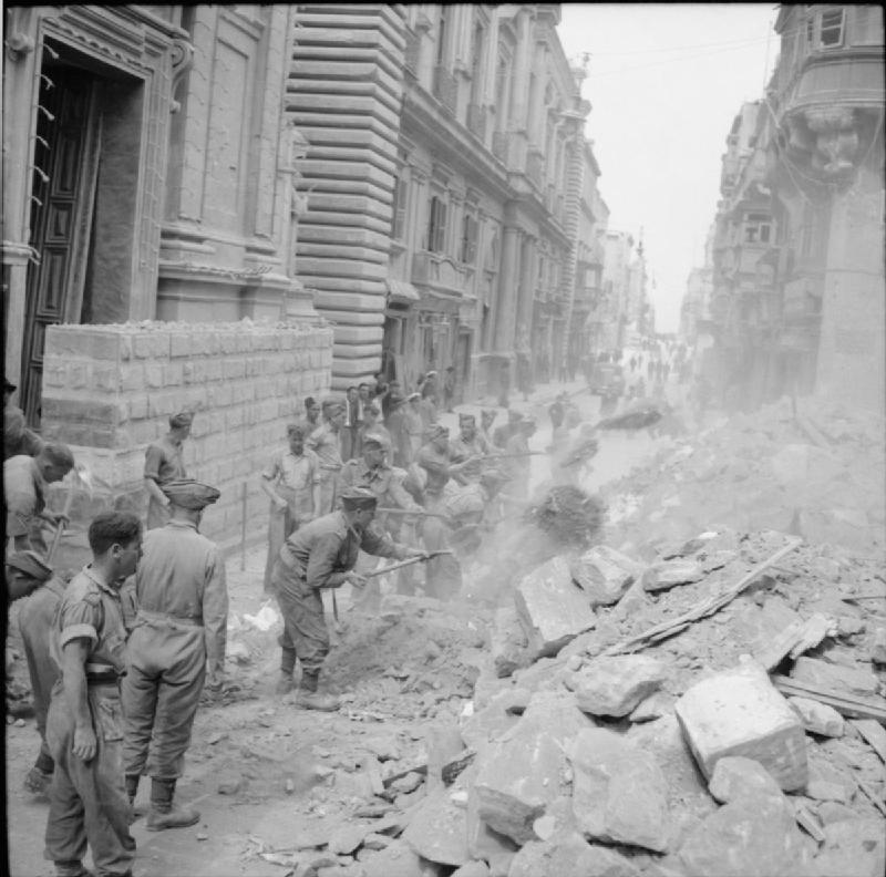 Soldiers clear rubble in a bombed-out street in Malta.